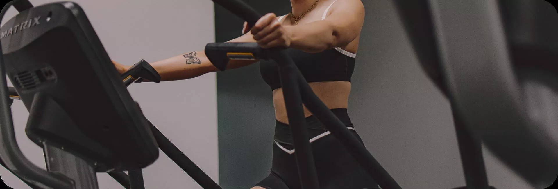 Various exercise equipment is viewed, including a rack of weights, some dumbbells', and ellipticals. . There is a neon green light that colors the entire image.